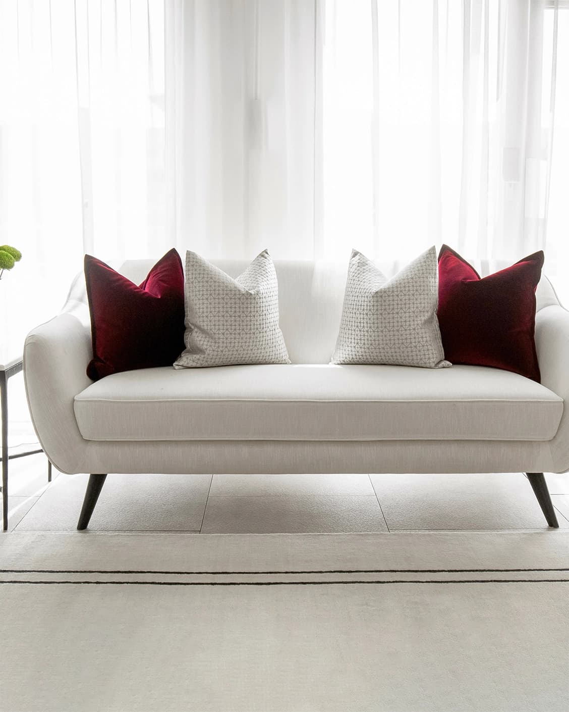 Cerise Bundle cushion in red, silver and white, shown in a lifestyle front view as image 4