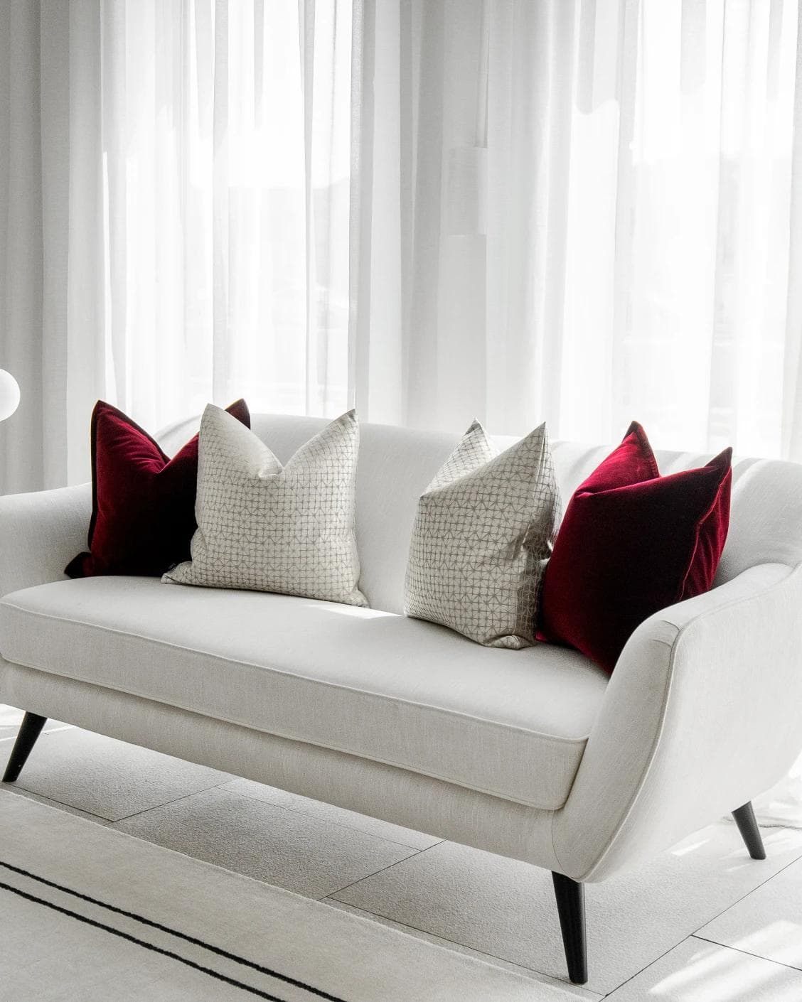 Cerise Bundle cushion in red, silver and white, shown in a lifestyle right view as image 2