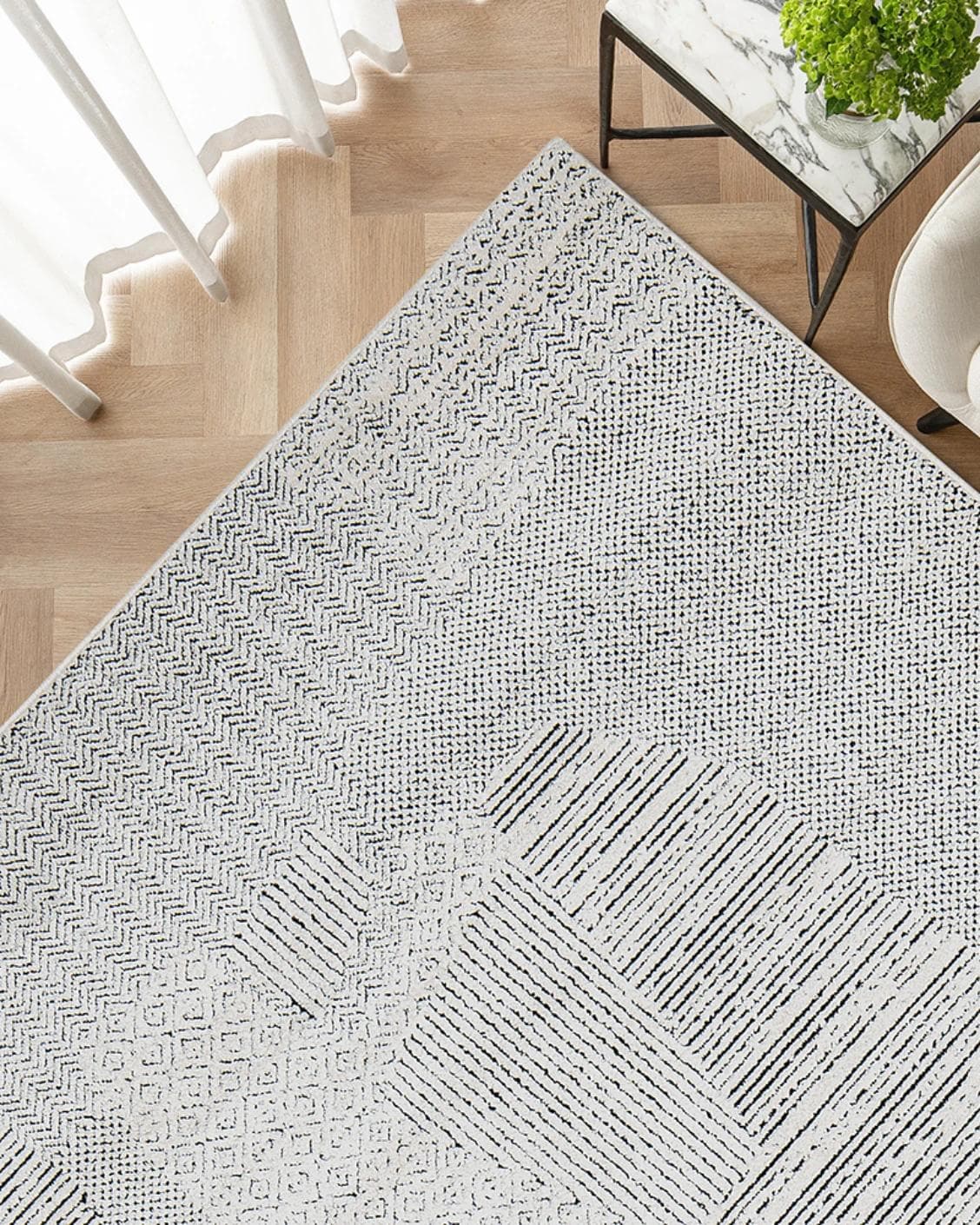 Renzo Dusty carpet in black and white, shown in a lifestyle top view as image 2