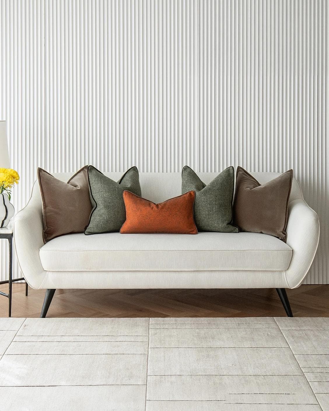 Roux Bundle cushion in orange, brown and green, shown in a lifestyle front view as image 4