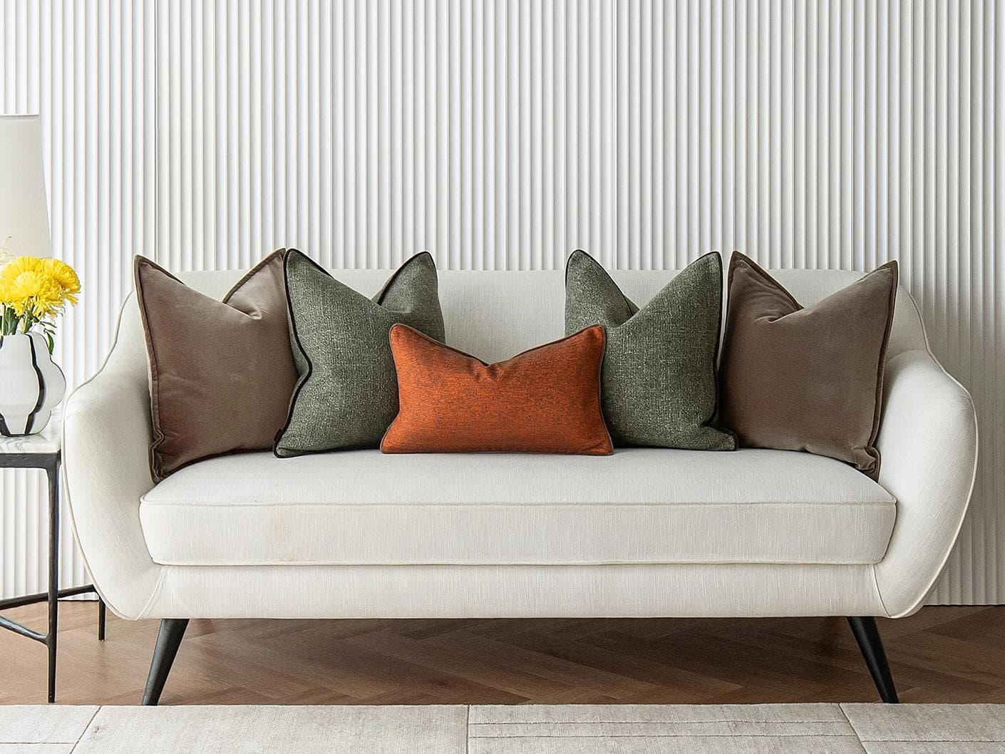 Roux Bundle cushion in orange, brown and green, shown in a lifestyle front view as image 4