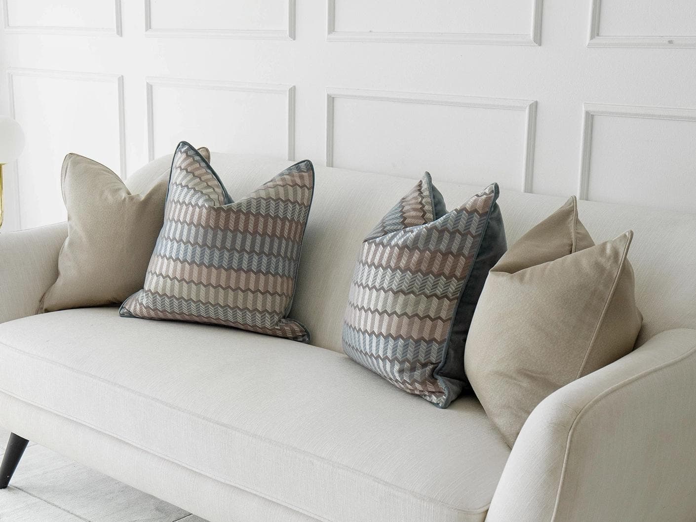 Evie Bundle cushion in silver, blue, gold and beige, shown in a lifestyle right view as image 2