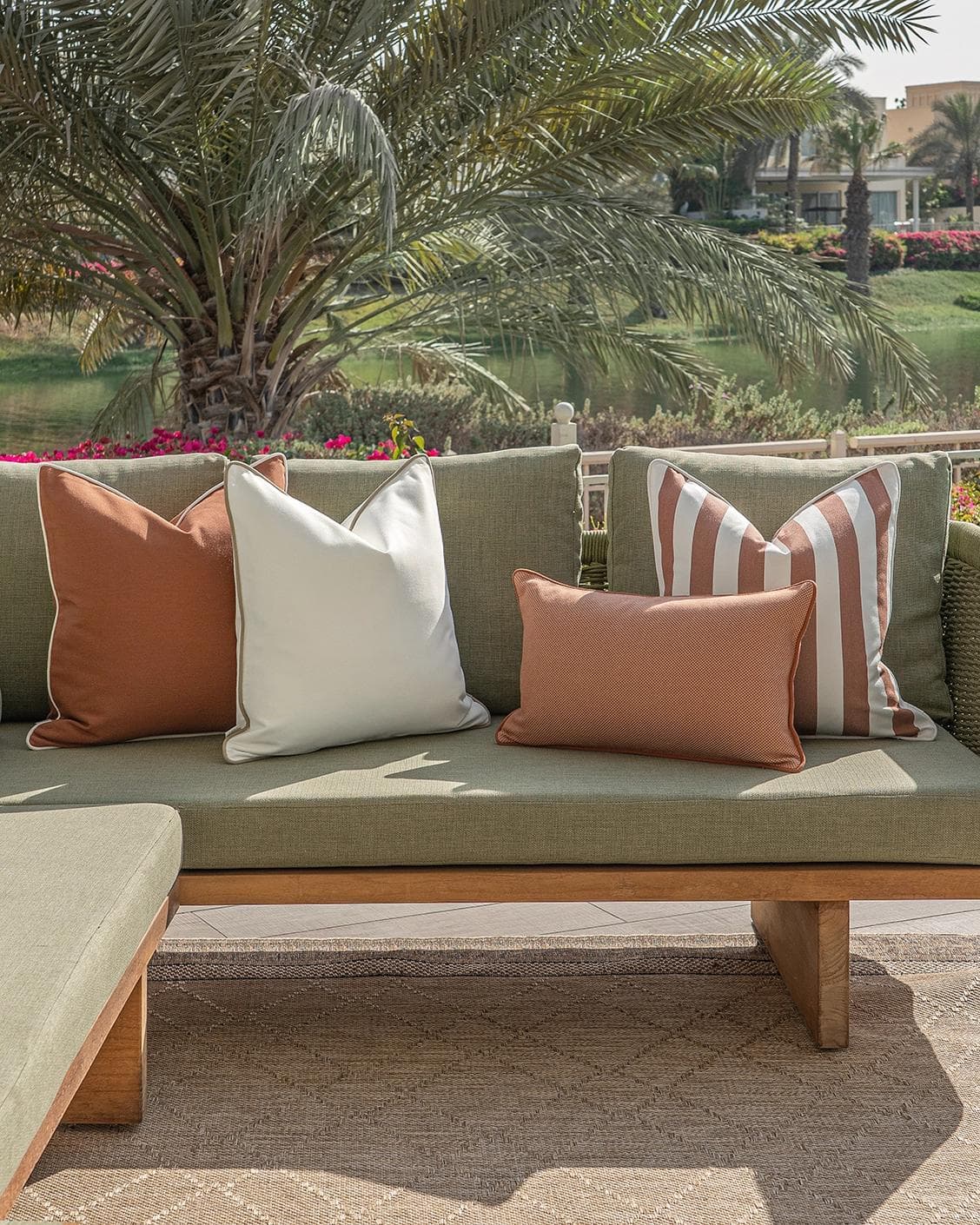 Sio Bundle cushion in rust and ivory, shown in a lifestyle front view as image 4