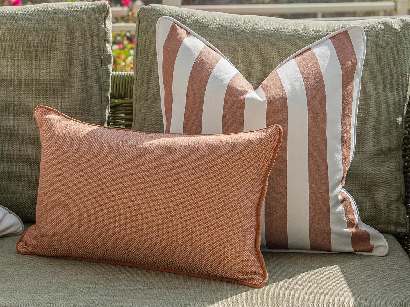 Sio Bundle cushion in rust and ivory, shown in a lifestyle front view as image 5