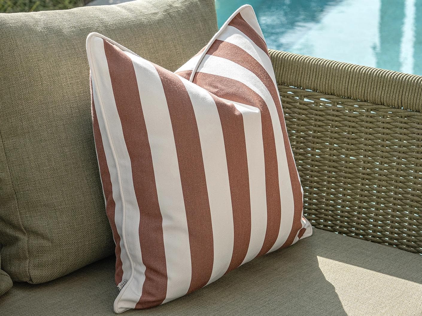 Sio Bundle cushion in rust and ivory, shown in a lifestyle left view as image 6