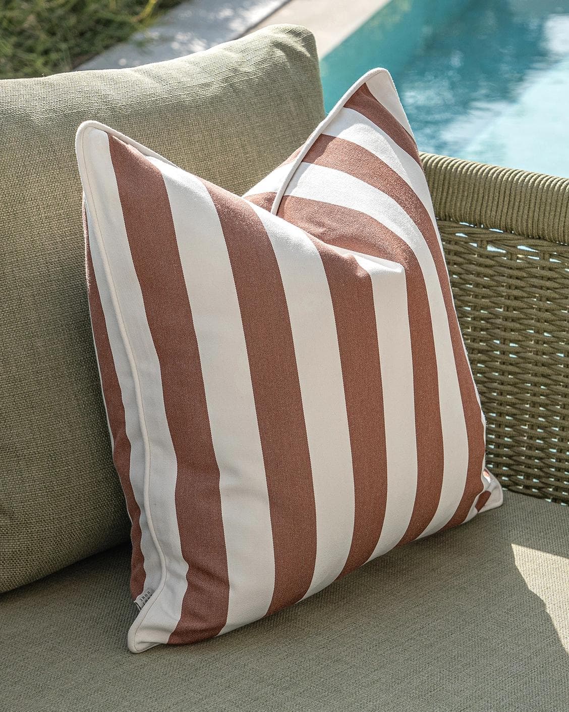 Sio Bundle cushion in rust and ivory, shown in a lifestyle left view as image 6