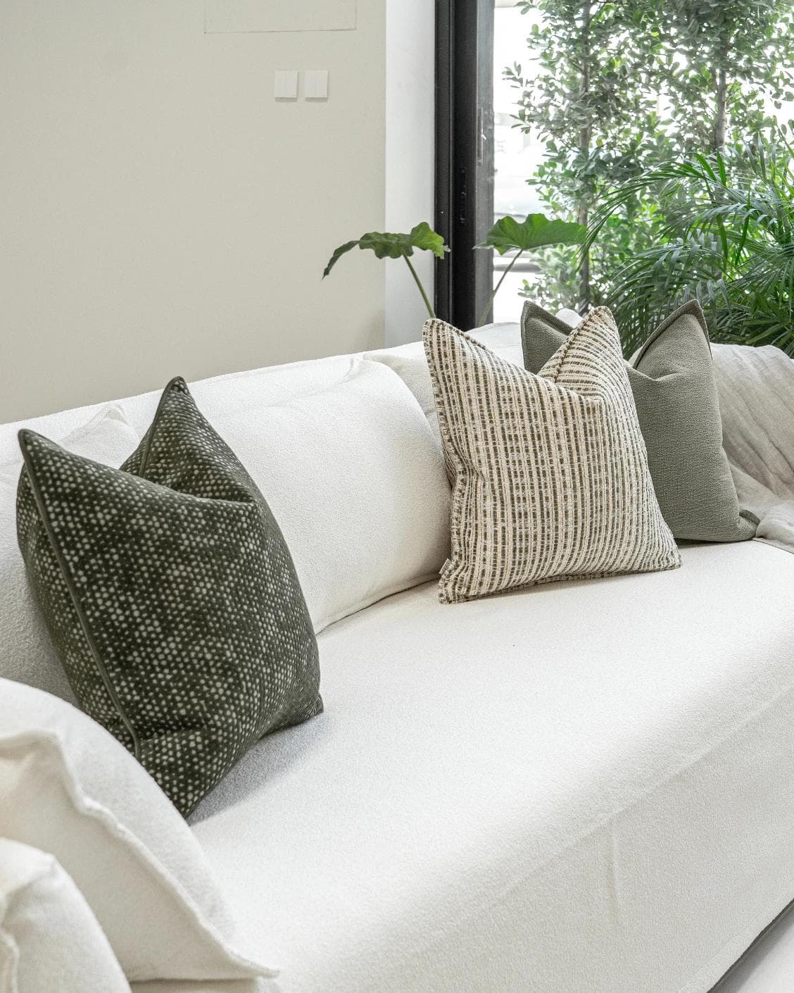 Suki Bundle cushion in green and beige, shown in a lifestyle left view as image 2