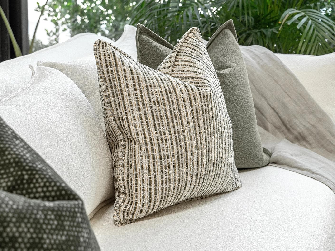 Suki Bundle cushion in green and beige, shown in a lifestyle left view as image 5