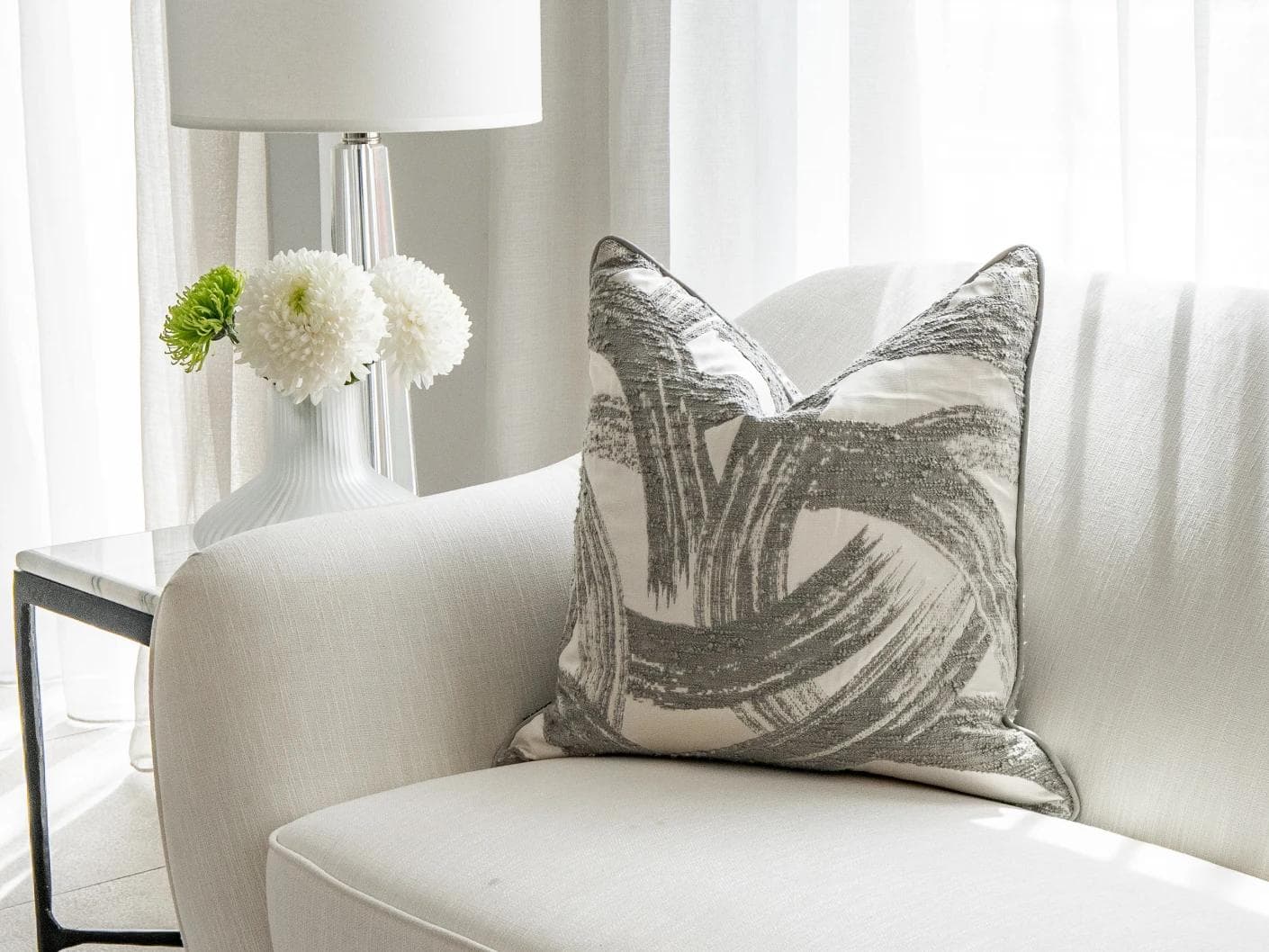 Tanya Laurent cushion in white and grey, shown in a lifestyle front view as image 2