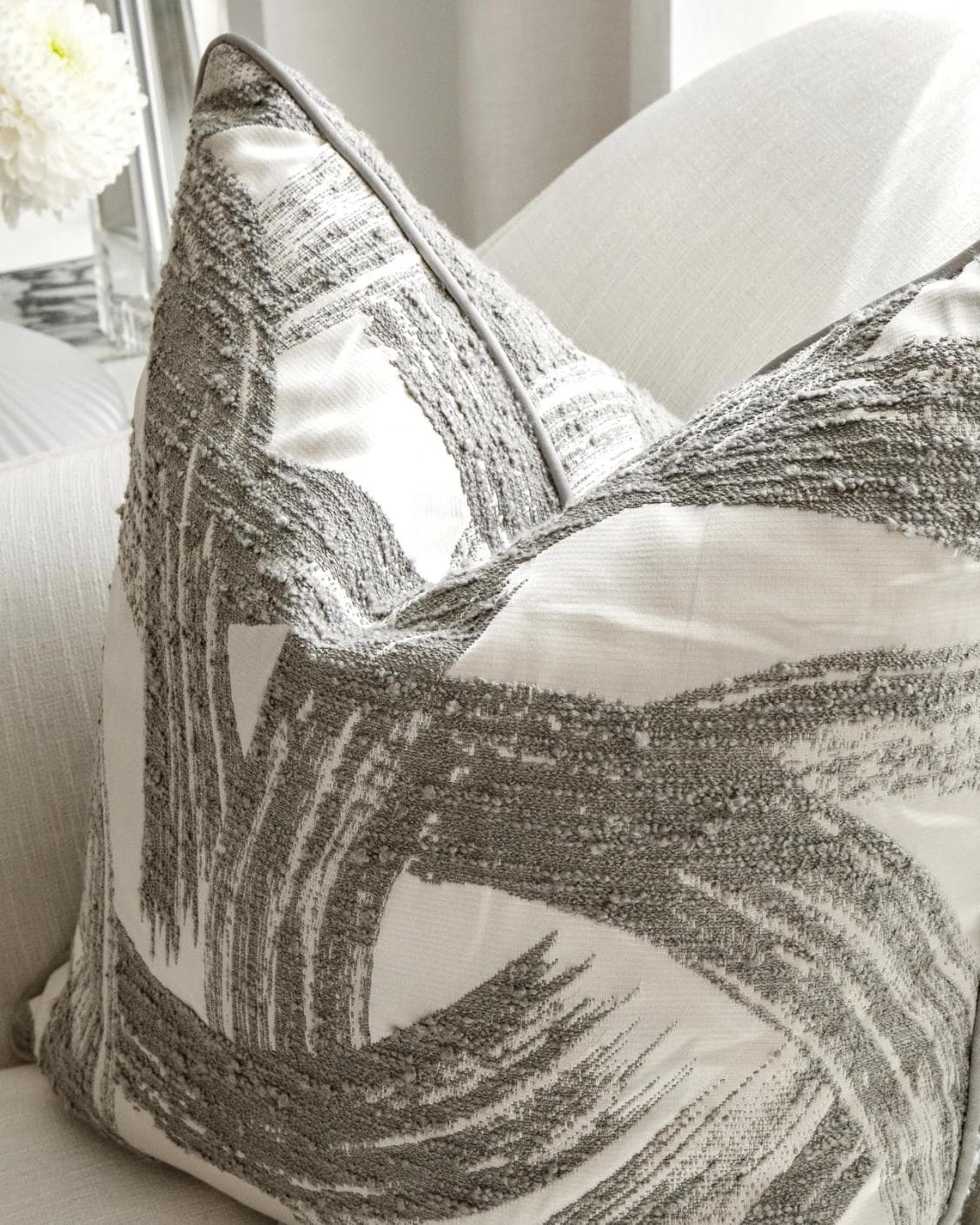 Tanya Laurent cushion in white and grey, shown in a lifestyle top view as image 6
