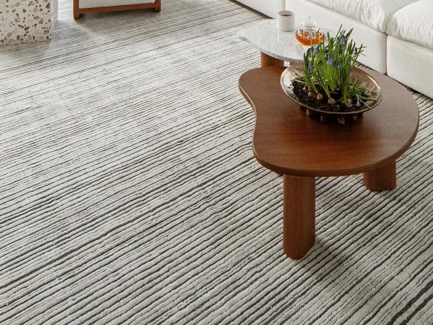 Theodore Ashton carpets in grey and ivory, shown in a lifestyle close-up as image 1