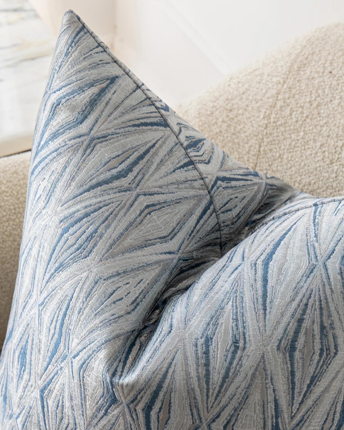 Titus Matisse cushion in silver and blue, shown in a lifestyle top view as image 6