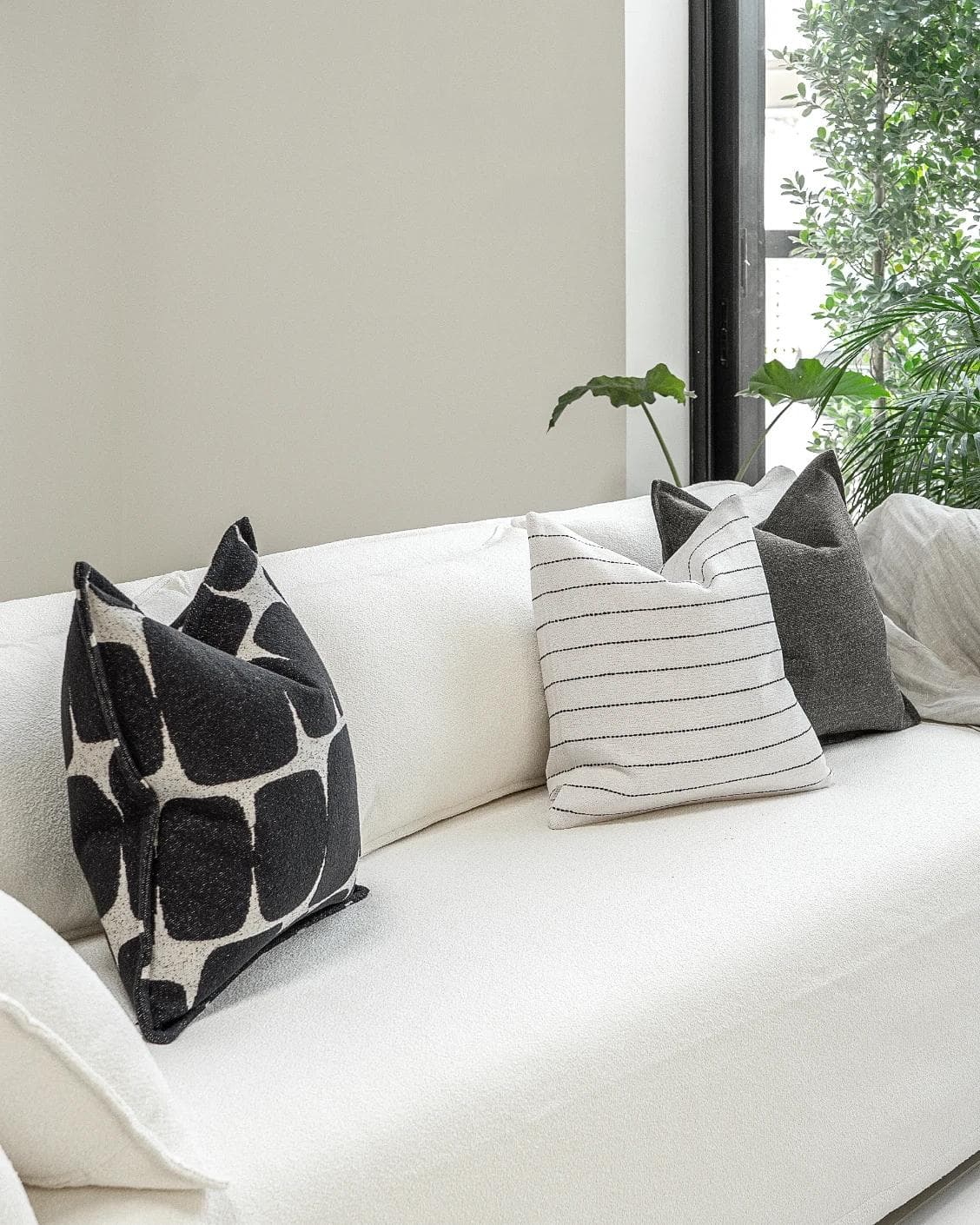 Tova Bundle cushion in black and white, shown in a lifestyle left view as image 2