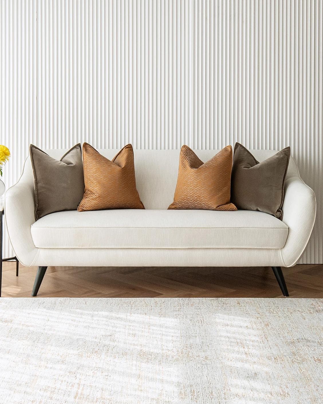 Jora Bundle cushion in brown and orange, shown in a lifestyle front view as image 2