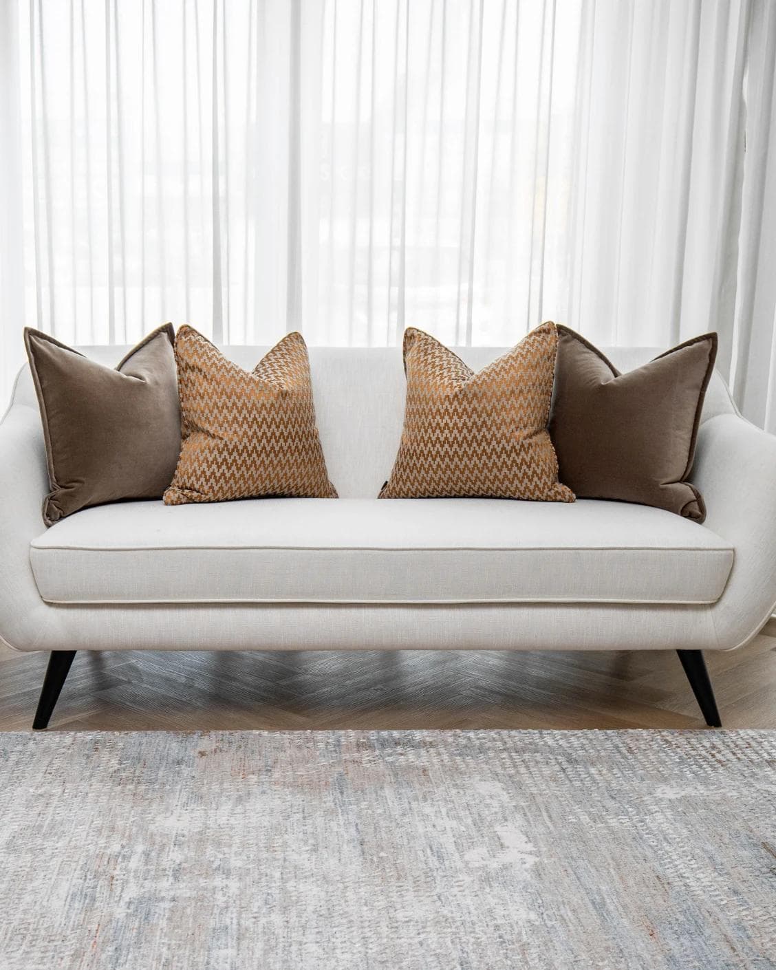 Vicente Bundle cushion in brown and orange, shown in a lifestyle front view as image 4