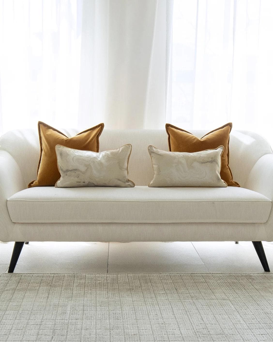 Johan Bundle cushion in orange, silver and yellow, shown in a lifestyle front view as image 4