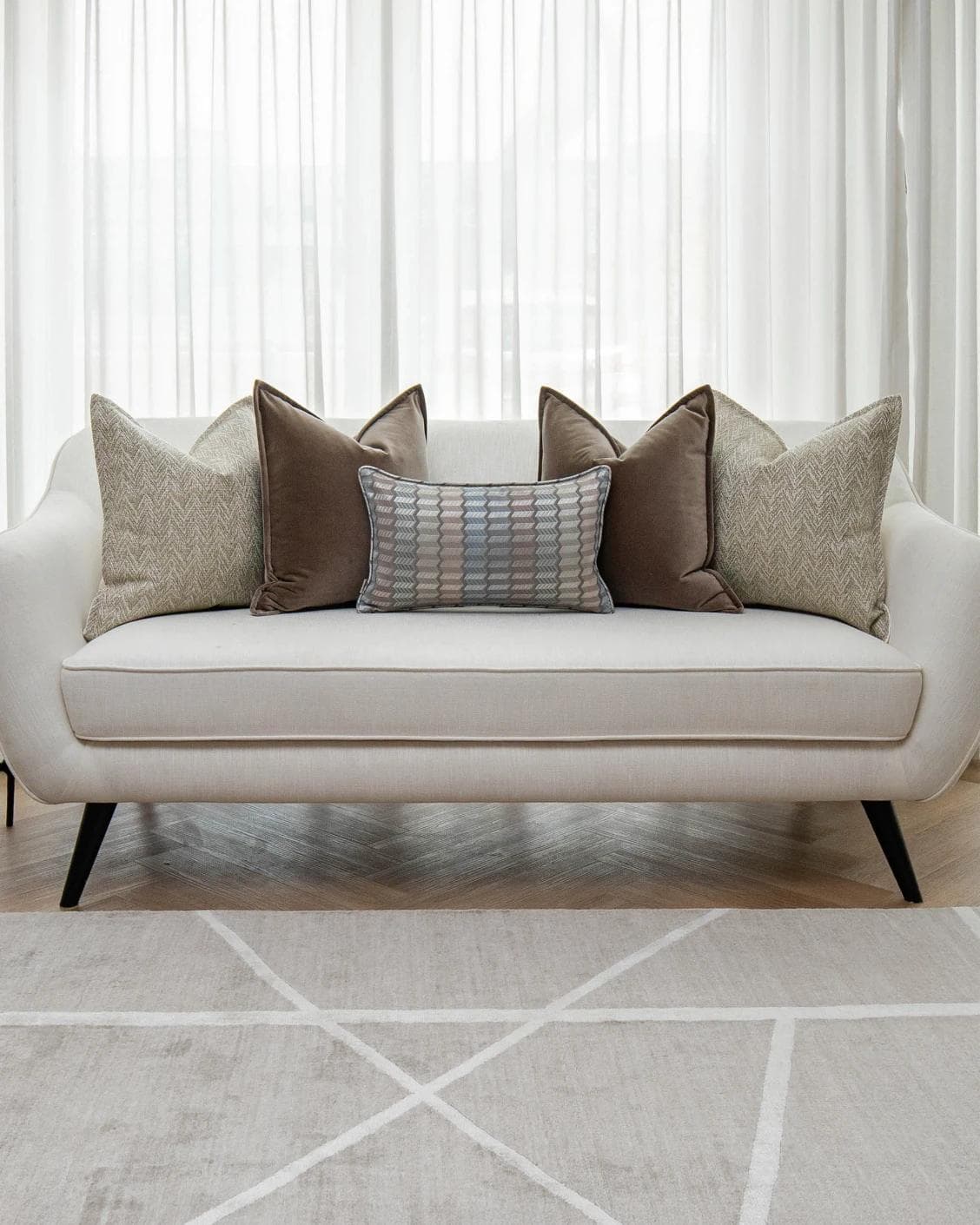 Jovie Bundle cushion in silver, blue, brown and beige, shown in a lifestyle front view as image 4