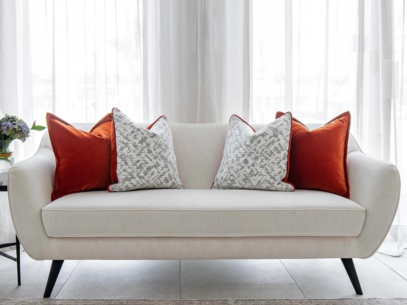 Braddy Bundle cushion in tan, orange, white and silver, shown in a lifestyle front view as image 4