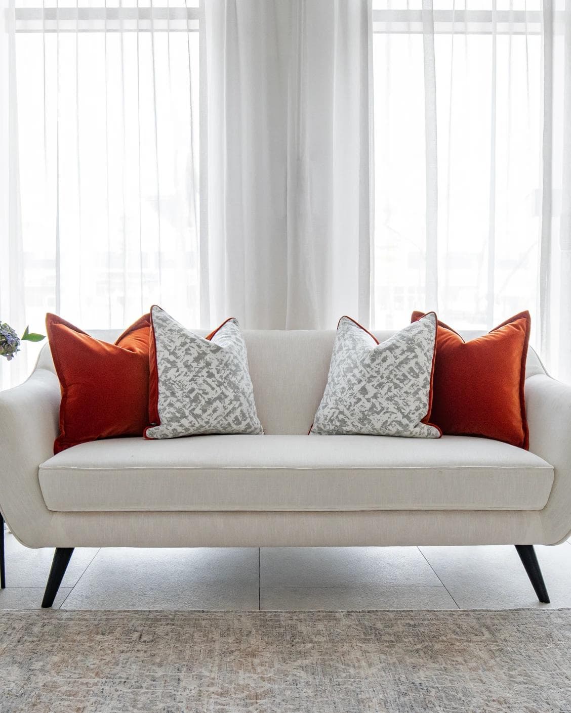 Braddy Bundle cushion in tan, orange, white and silver, shown in a lifestyle front view as image 4