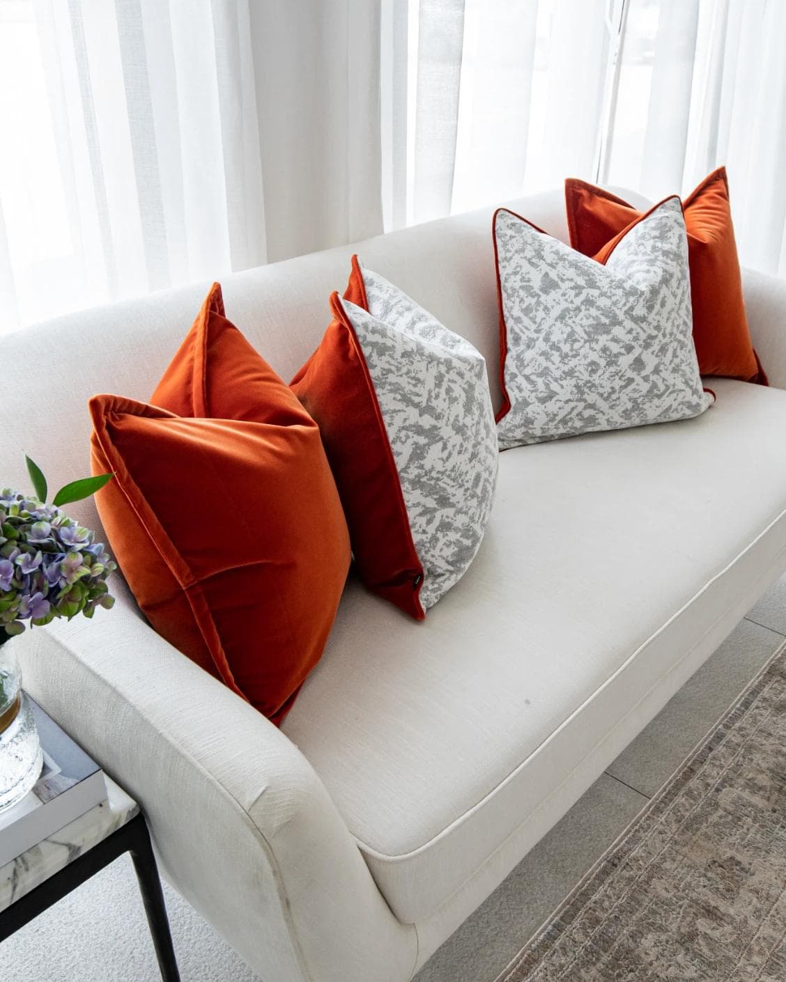Braddy Bundle cushion in tan, orange, white and silver, shown in a lifestyle top view as image 6