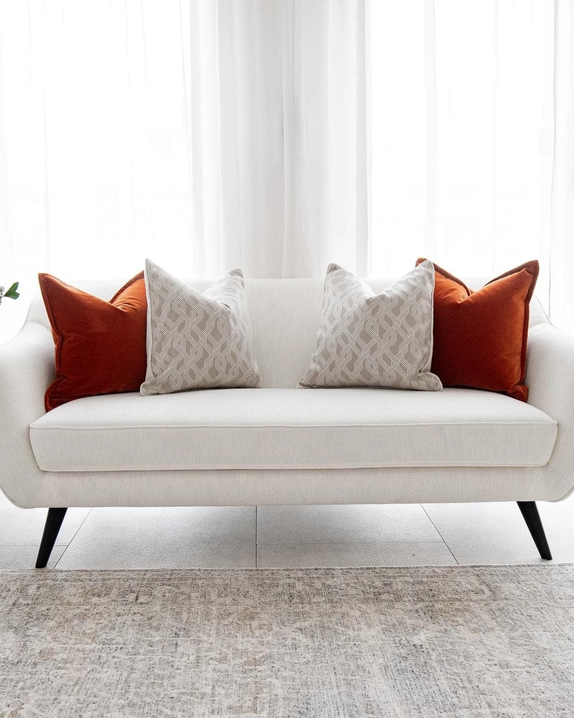 Marites Bundle cushion in tan, orange, beige and white, shown in a lifestyle front view as image 4