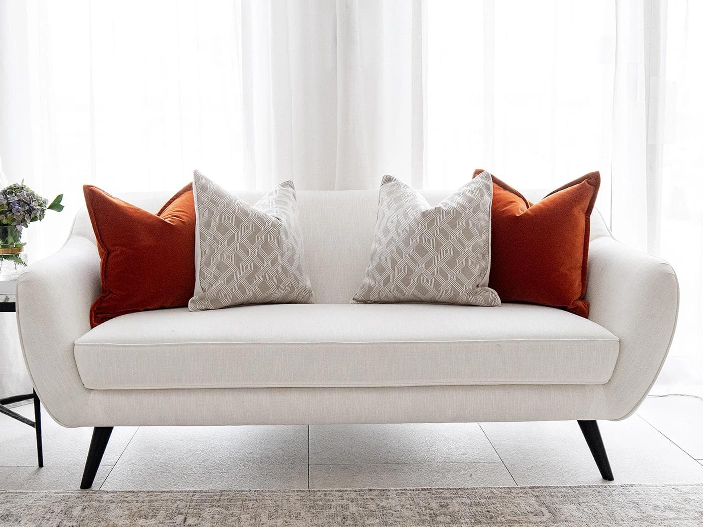 Marites Bundle cushion in tan, orange, beige and white, shown in a lifestyle front view as image 4
