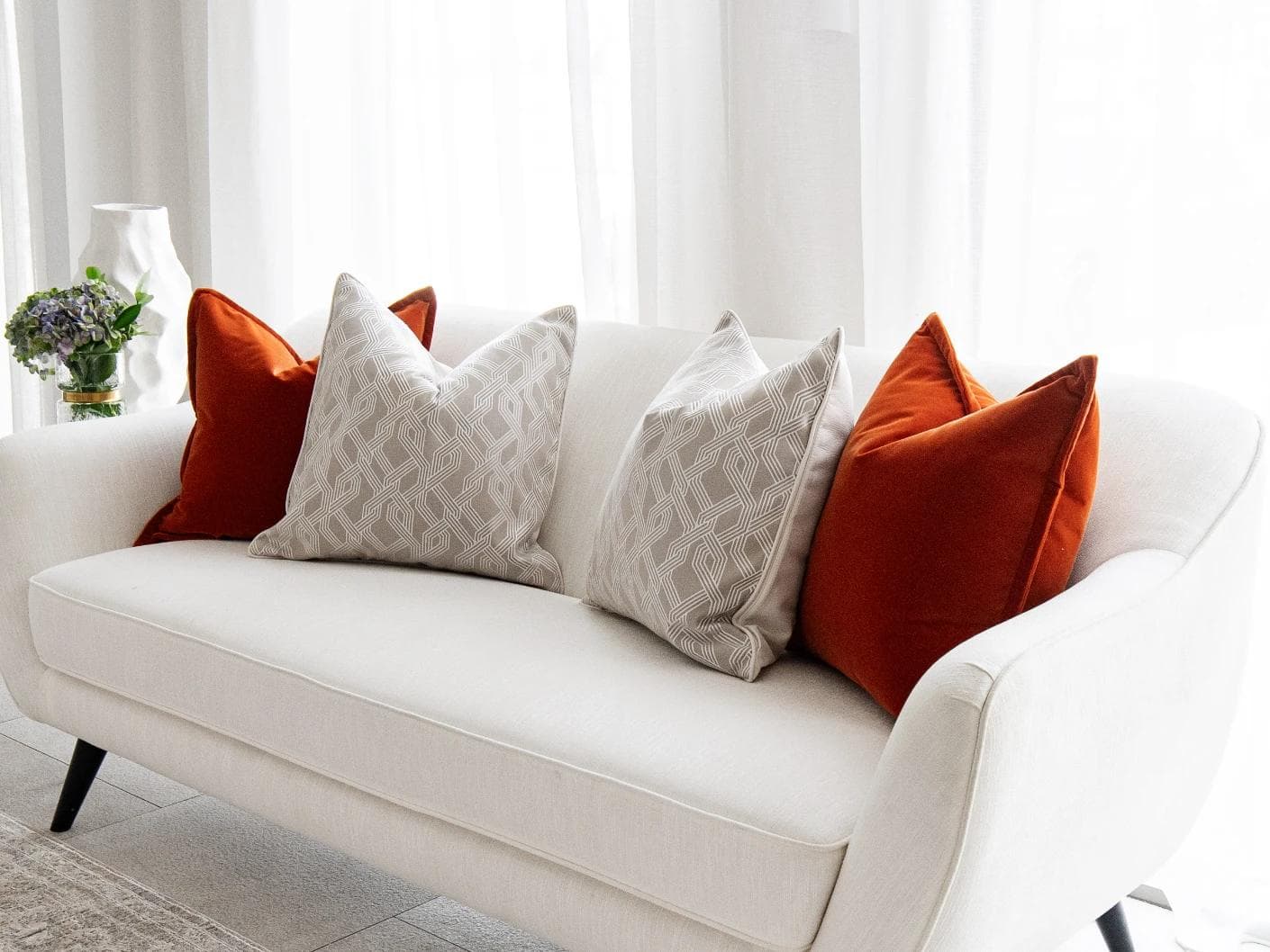 Marites Bundle cushion in tan, orange, beige and white, shown in a lifestyle right view as image 2