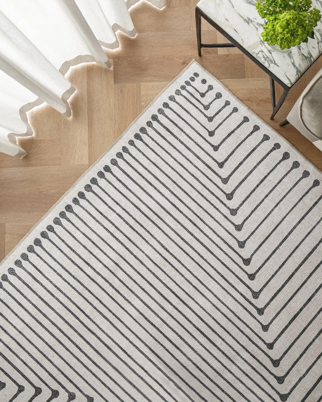 Vince Bianca carpet in black and white, shown in a lifestyle top view as image 2
