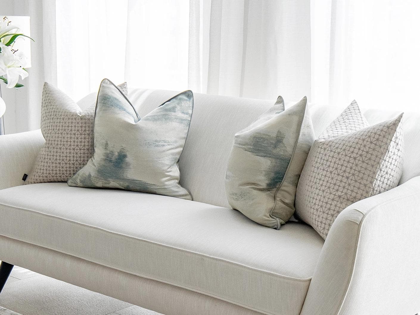 Orlan Bundle cushion in blue, silver and white, shown in a lifestyle right view as image 2