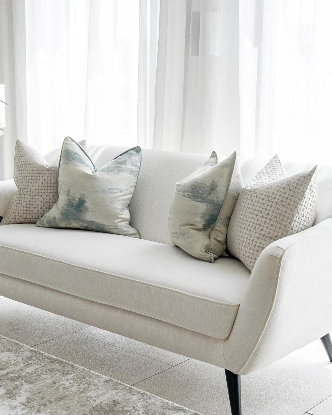 Orlan Bundle cushion in blue, silver and white, shown in a lifestyle right view as image 2