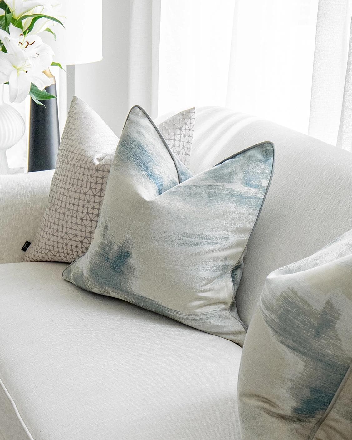 Orlan Bundle cushion in blue, silver and white, shown in a lifestyle right view as image 5