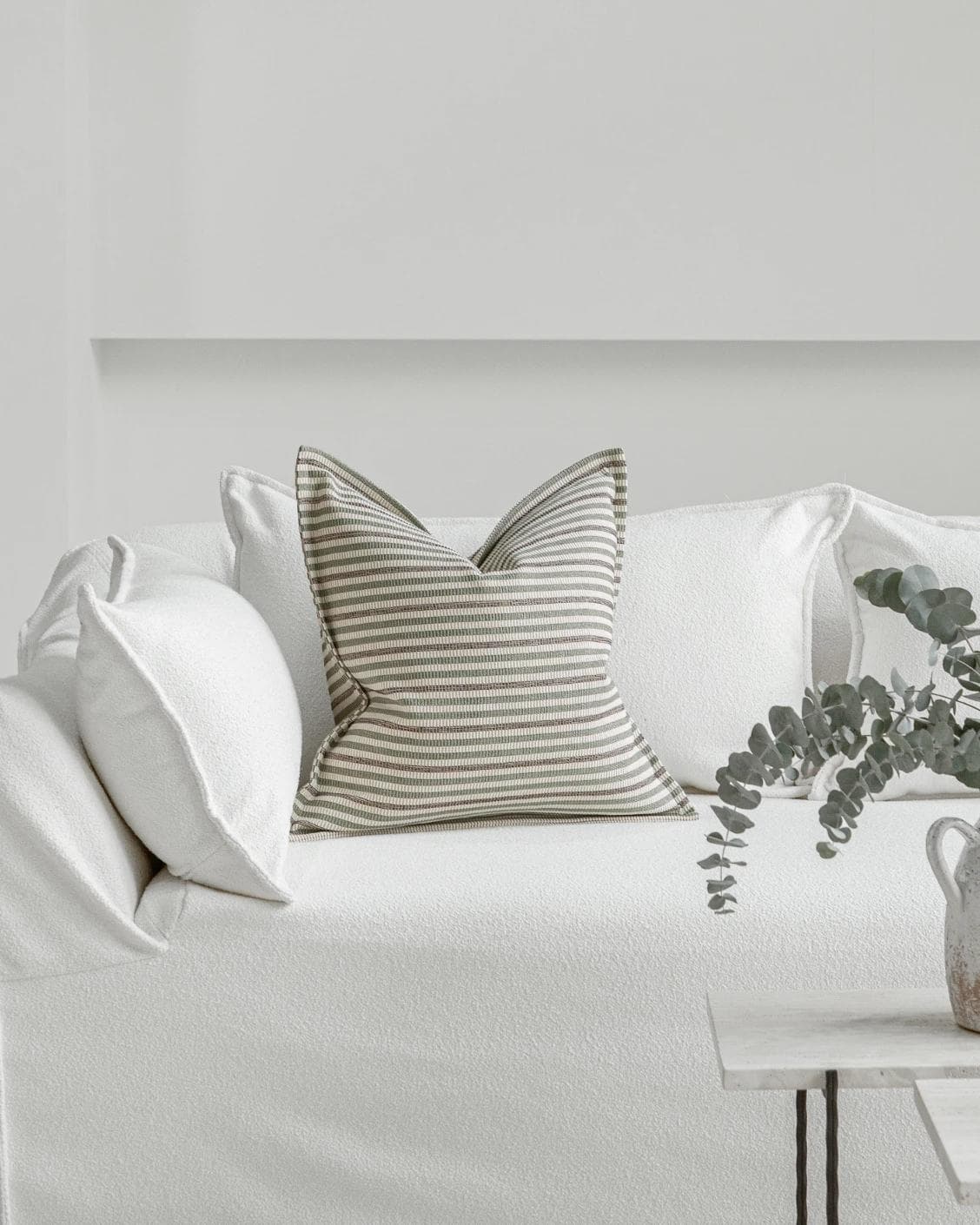 Wren Pistachio cushion in green and ivory, shown in a lifestyle front view as image 4