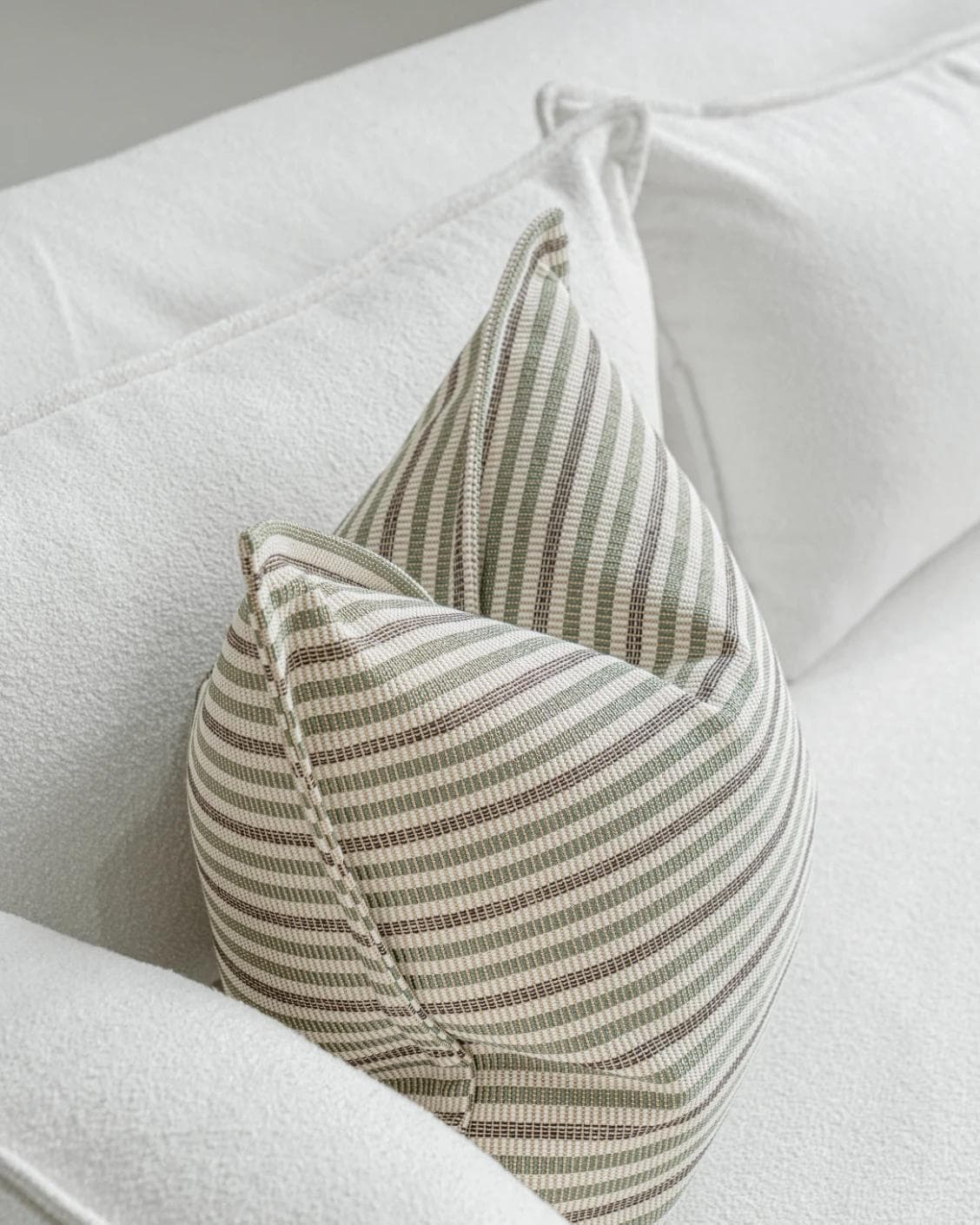 Wren Pistachio cushion in green and ivory, shown in a lifestyle top view as image 5