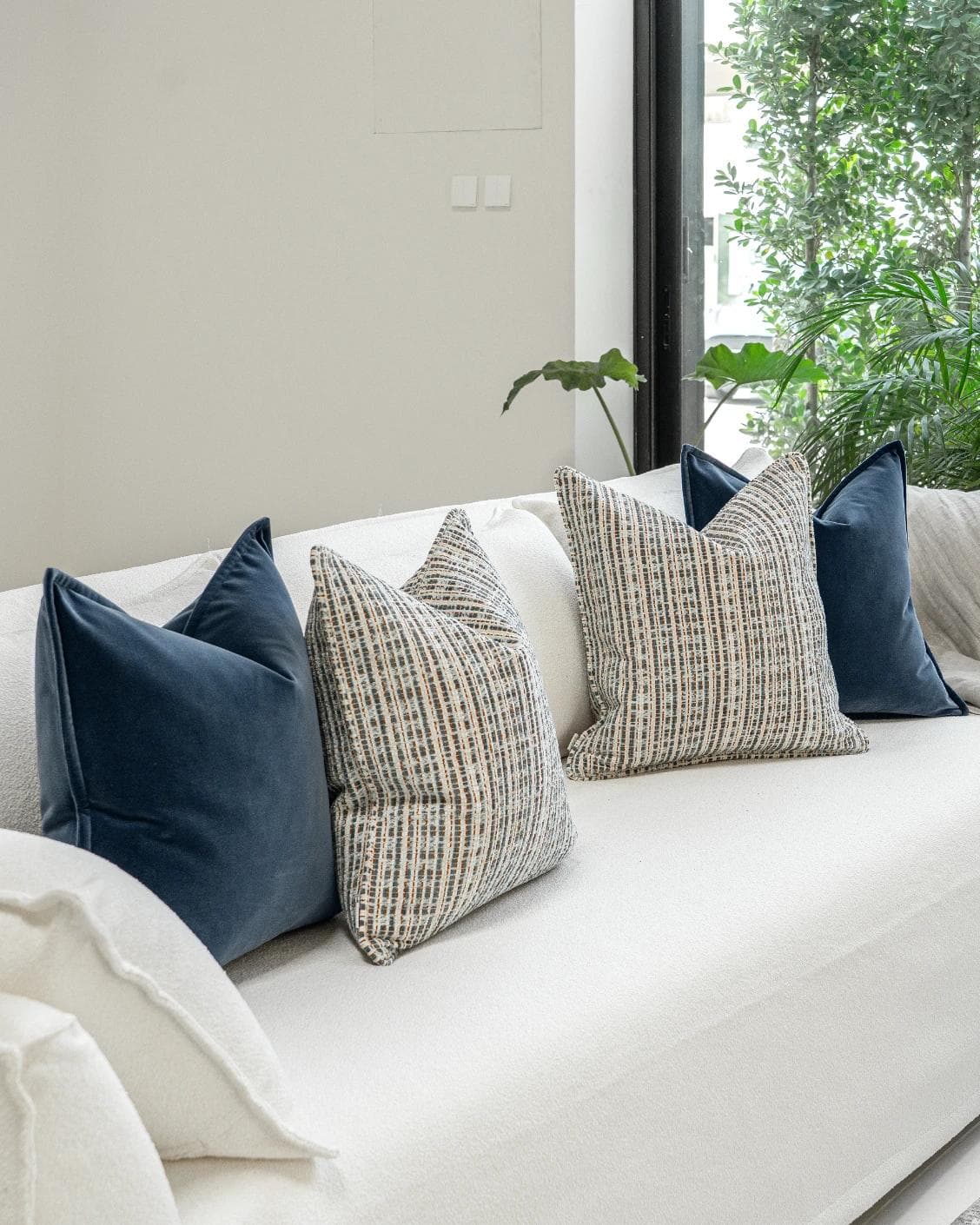 Yakshith Bundle cushion in blue and cream, shown in a lifestyle left view as image 2