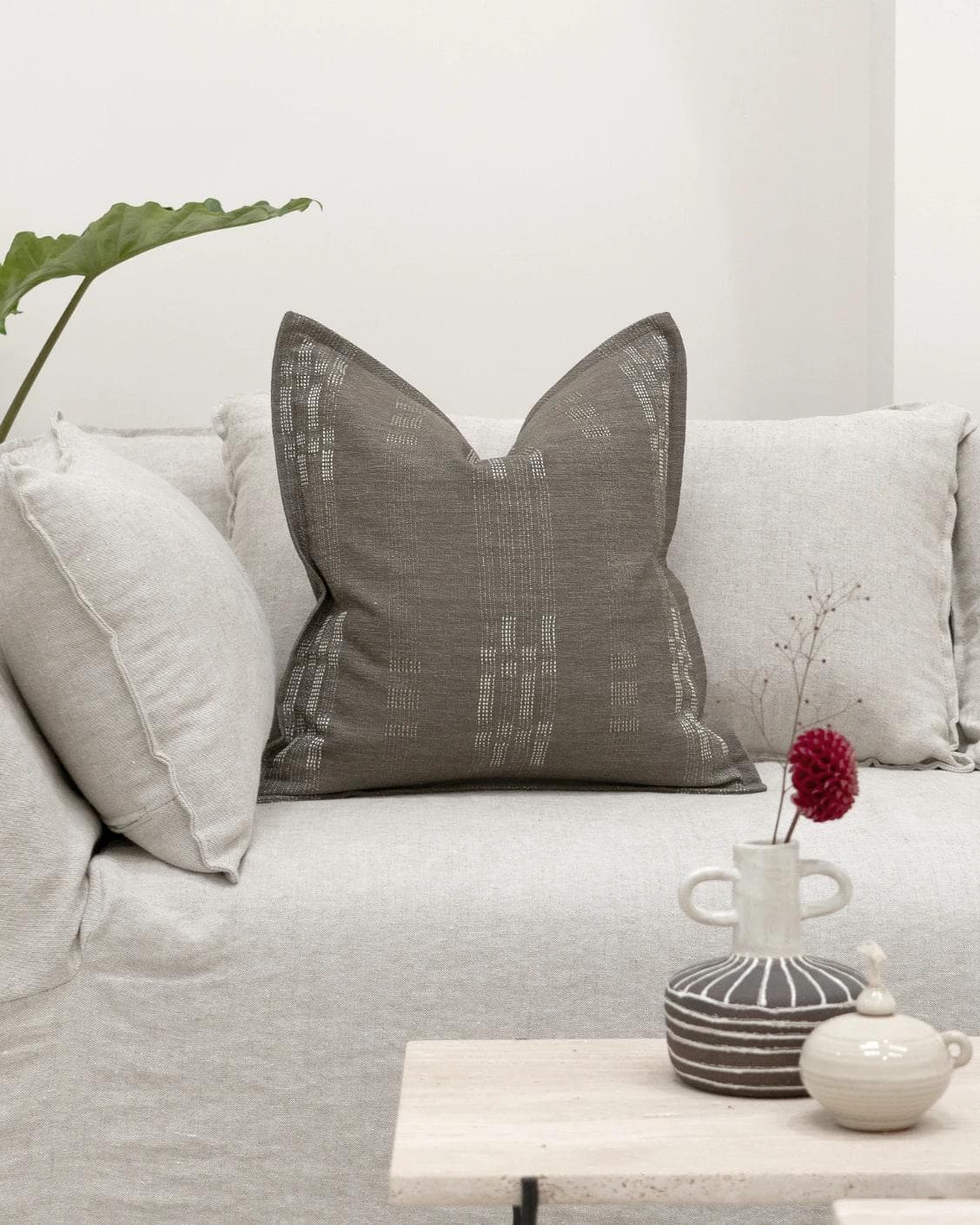 Yon Laurent cushion in taupe and charcoal, shown in a lifestyle front view as image 4