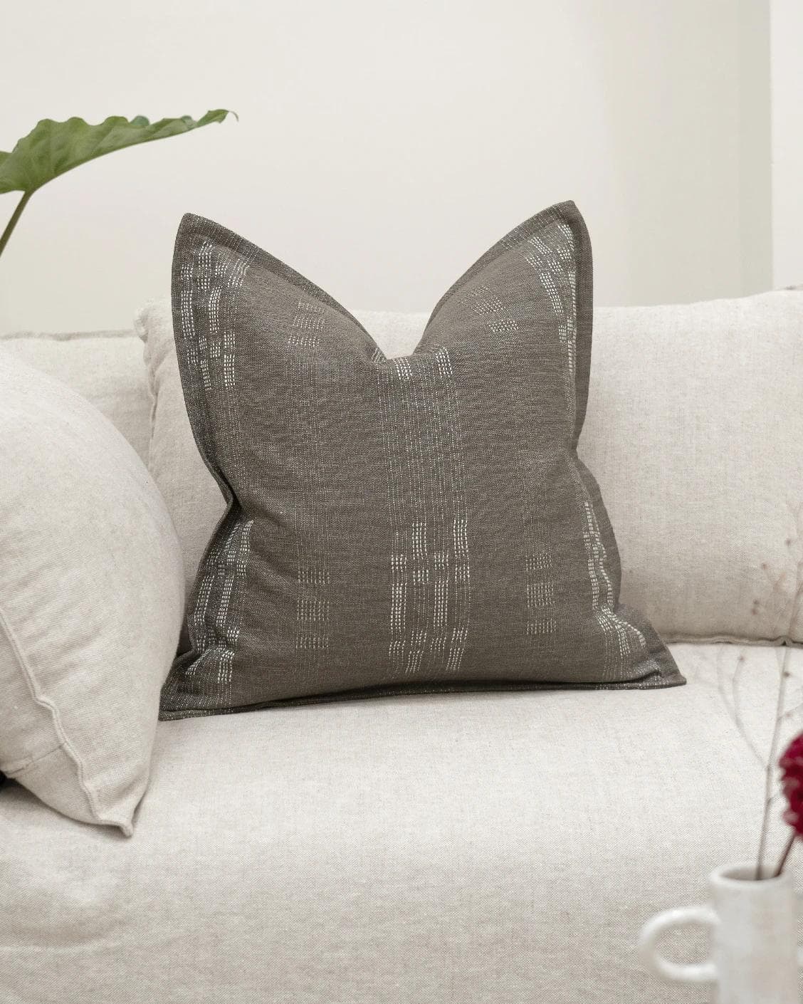Yon Laurent cushion in taupe and charcoal, shown in a lifestyle front view as image 2