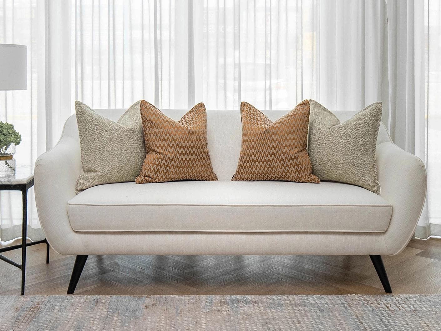 Janna Bundle cushion in orange and beige, shown in a lifestyle front view as image 4