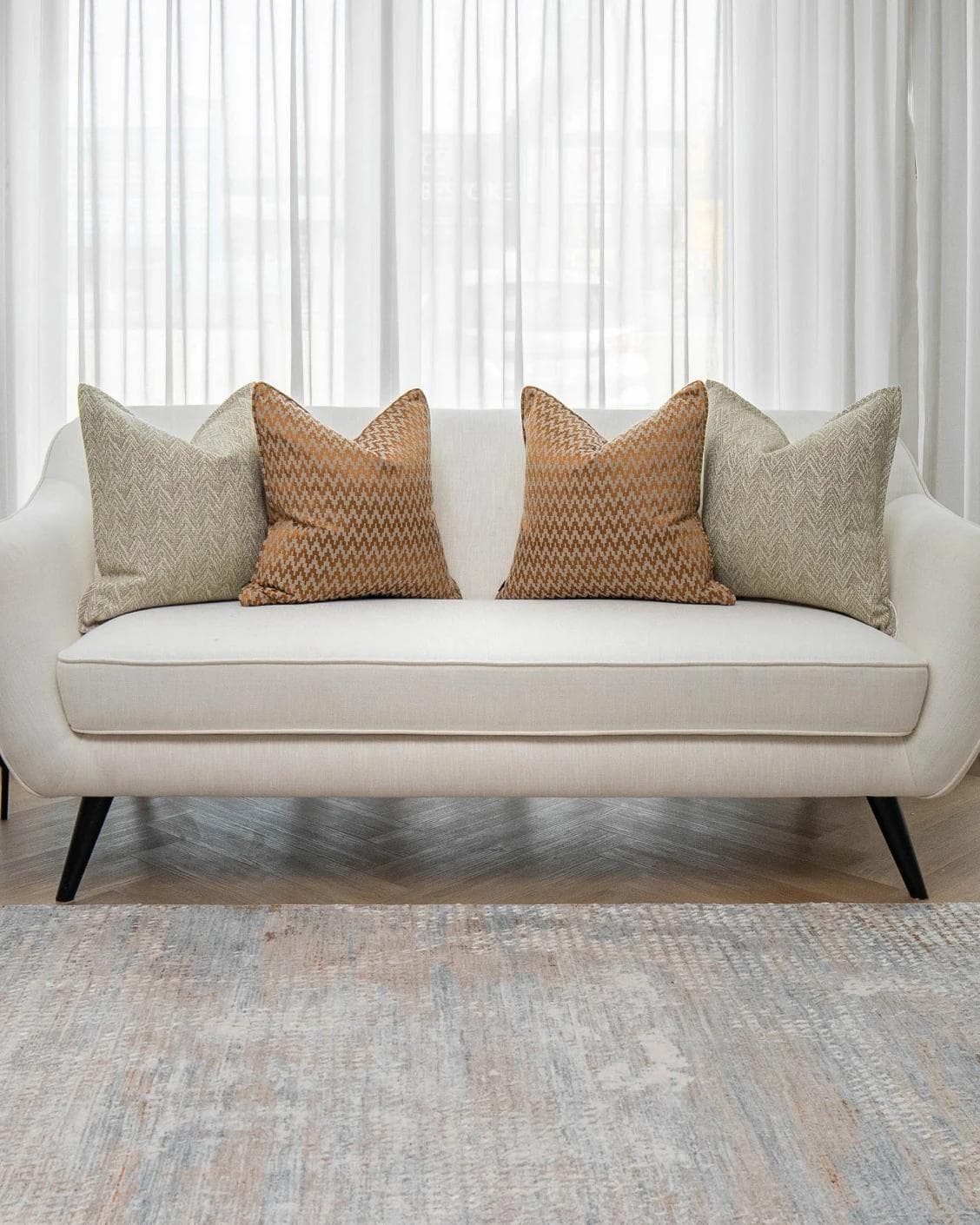 Janna Bundle cushion in orange and beige, shown in a lifestyle front view as image 4