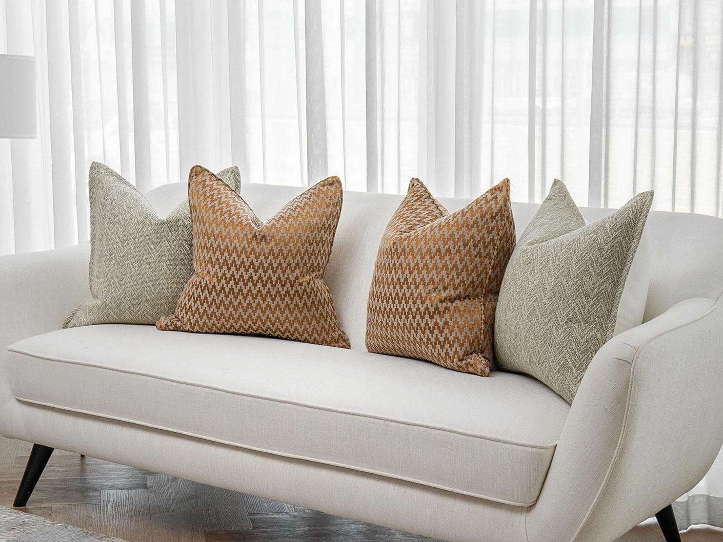 Janna Bundle cushion in orange and beige, shown in a lifestyle right view as image 2