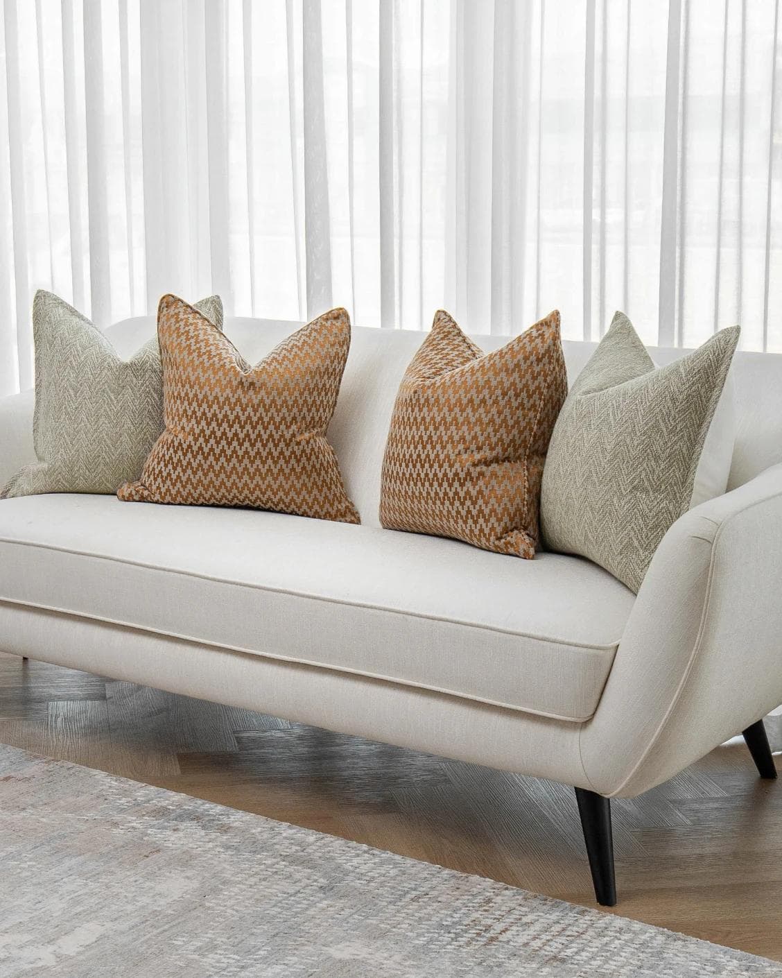 Janna Bundle cushion in orange and beige, shown in a lifestyle right view as image 2