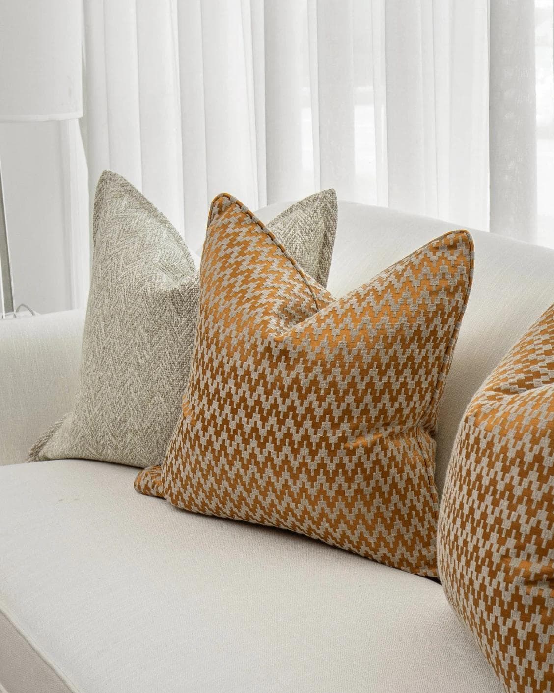 Janna Bundle cushion in orange and beige, shown in a product right view as image 5